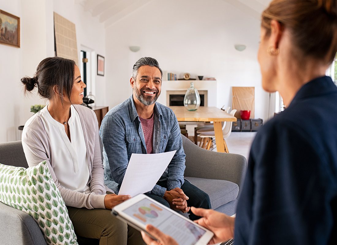 About Our Agency - Happy Couple Sit Together on a Sofa at Home While Talking to an Insurance Agent